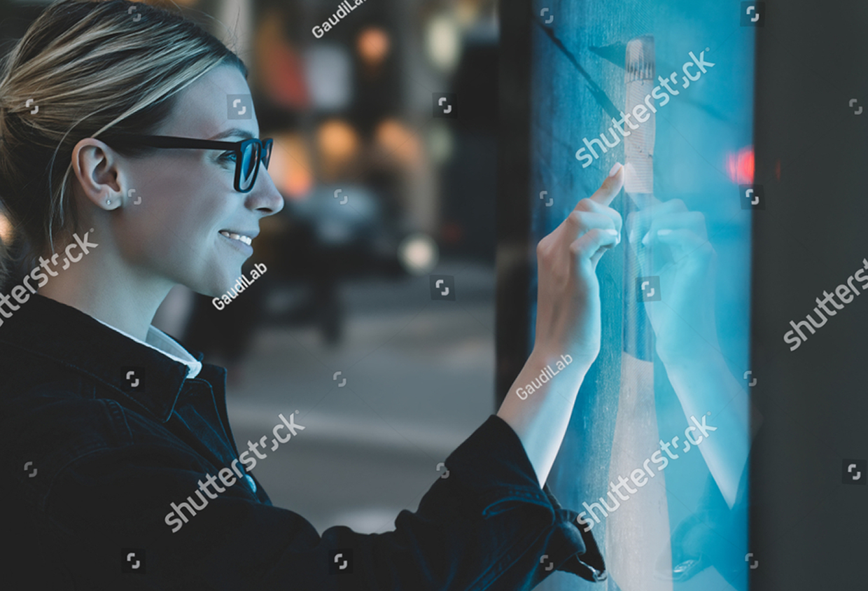 stock-photo-smiling-female-standing-at-big-display-with-advanced-digital-technology-young-woman-touching-with-1161254959