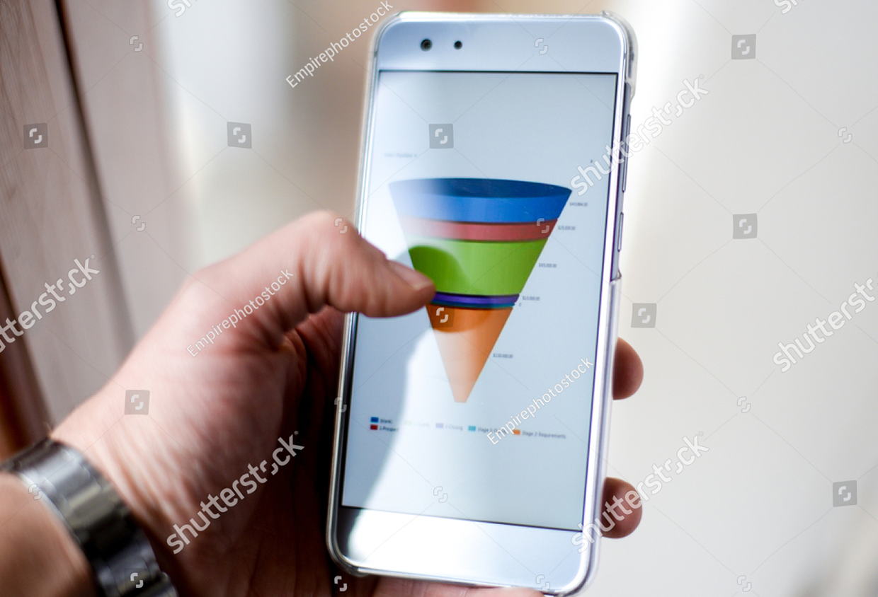 stock-photo-male-hand-holding-a-smart-phone-showing-a-marketing-sales-funnel-diagram-1298785111